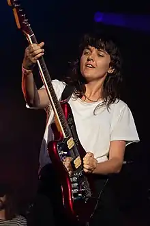 Barnett playing guitar and smiling