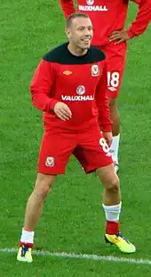 A footballer wearing a red kit