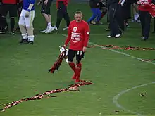 A footballer holding a trophy