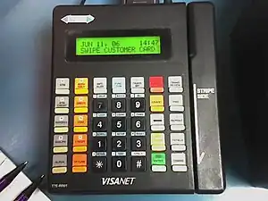 A typical credit card terminal popular in 2005, now typically out of use and of a style/era usually non-compliant per PCI-DSS standards.