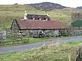 Croft in Upper Ardelve, a Highland settlement on Loch Alsh (2007). Image shows farmhouse behind a modest livestock shed. Cows graze the rear fields.