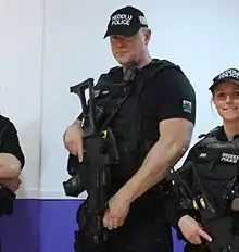 Baseball caps of North Wales Police displaying the word POLICE in English and the Welsh language.