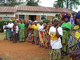 Female rape victims stand in front of a "peace hut".