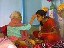 Senior offering Dashain Tika to junior