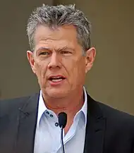 David Foster speaking in front of a microphone