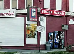 Old N.Y. State Highway signs at the corner of Utica and Cortland Streets (NYS Rt. 13) in the Village of DeRuyter. The building was the DeRuyter Big M. July 2001 photo.