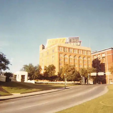 Hertz Rent A Car sign with digital time and temperature display on top of the Texas School Book Depository in 1969, Dealey Plaza, Dallas, Texas, facing Stemmons Freeway