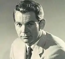 Black and white photo of a man posing and looking into the camera