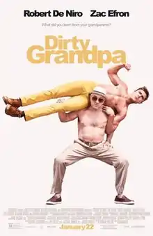 Two topless men. The older man is lifting the younger man horizontally across his shoulders.