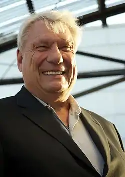 Nelson smiling, wearing a suit