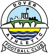 A simplified illustration of a castle atop white cliffs, with the sea below, all surrounded in a circular border containing the words "Dover Athletic", with a scroll below containing the words "Football Club"