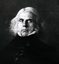 A black and white image, likely the reproduction of a painting, depicting a middle-aged man with long white hair