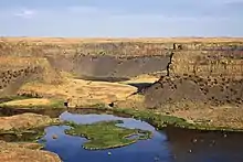 Plateau with steep walls of a former waterfall above a river