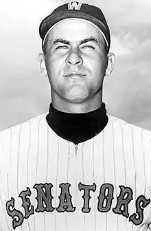 A man wearing a baseball cap and jersey with "Senators" written across the chest.