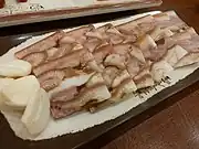 Dwaeji-meori-pyeonyuk (pressed boiled pork head slices) served with garlic