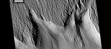 Surface features along a scarp in Medusae Fossae formation, as seen by HiRISE under HiWish program. Location is Memnonia quadrangle.