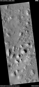 Wide view of layered buttes and small mesas, as seen by HiRISE under HiWish program.  Some dark slope streaks are visible.