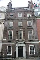  A brownish brick townhouse with stone trim