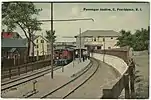 color picture of maroon passenger train stopped at station