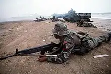 An Ecuadorian Marine with a HK-33 rifle, during an amphibious assault exercise (UNITAS), in the background a US Amphibious Assault Vehicle.