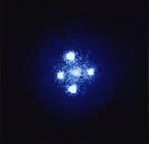 Five balls of light are arranged in a cross shape.