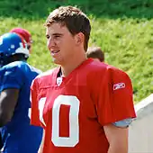 An American football player wearing a red jersey with a white number "10".