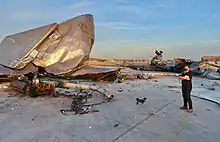 Photograph of Elon Musk alongside the remains of Starship