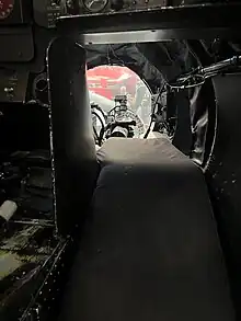 Interior shot of the bomber's position, showing a mattress that allows the crew member to lay comfortably as well as the glass dome in front, through which the crew member would control the plane during bombing.