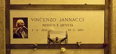 A marble gravestone on the wall of a crypt