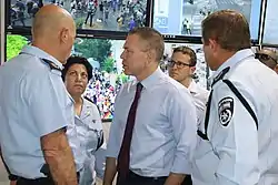 Erdan visiting a police control center during the 2019 Pride Parade in Jerusalem, with Police Commissioner Moti Cohen and commander of the Jerusalem district, Doron Yadid.