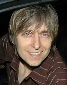 Head shot of a man wearing a brown-striped shirt