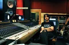 A color photograph of music producer Eric Valentine sitting inside a recording studio.