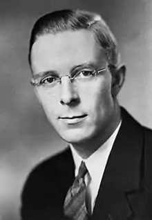 A head and shoulders shot of a young bespectacled man with short dark hair