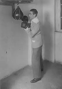 Deutsch posing with boxing gloves and a punching bag