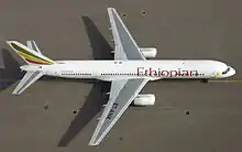 Overhead view of twin-jet aircraft taxiing on airport tarmac.