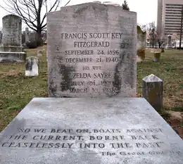 A color photograph of a grave in a cemetery. The headstone reads Francis Scott Key Fitzgerald September 24, 1896, December 21, 1940. His Wife Zelda Sayre July 24, 1900, March 10, 1948. "So we beat on boats against the current, borne back ceaselessly into the past" – The Great Gatsby