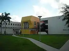 A gray building with a bright yellow entrance