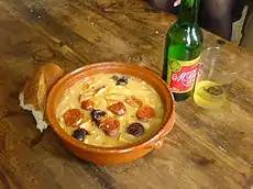 Fabada asturiana, a rich Spanish bean stew, as typically served with crusty bread and Asturian cider