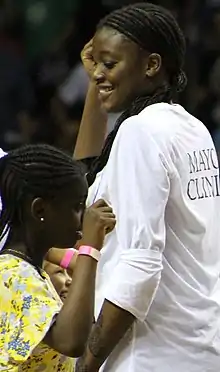 Smiling Fagbenle dancing with young girl fan