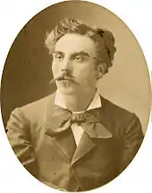 young man in semi profile, with luxuriant moustache and longish dark hair