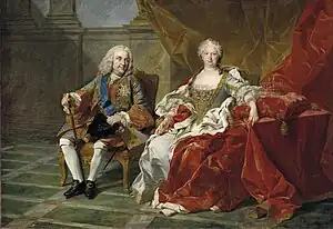 Royal couple seated in a sumptuous marble hall on thrones, the queen in a bejeweled white silk dress with her arms on a red pillow holding a crown. The king, in a silvery-blue military coat, is looking towards his wife.