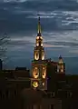 An evening view of the building's illuminated steeple