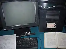 A NeXT Computer workstation has a black monitor, system box, keyboard, and mouse.