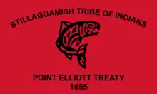 Flag of the Stillaguamish Tribe of Indians. The flag is a red banner with a salmon drawn in the traditional Coast Salish art style. Above the salmon is written "Stillaguamish Tribe of Indians." Below the salmon is written "Point Elliott Treaty 1855"