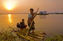 A woman using a raft to transport her daughter and goats