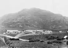 A panoramic view of a military camp at the base of a mountain