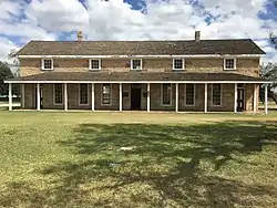 A portion of the parade ground (bottom half) and the fort headquarters building (upper half)