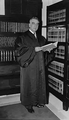 A formal portrait of an older man, sitting, in judicial robes