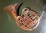 A rose gold French Horn