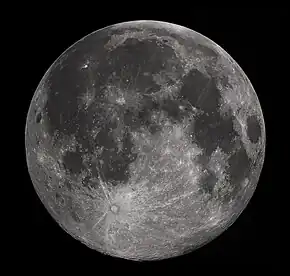 Full Moon in the darkness of the night sky. It is patterned with a mix of light-tone regions and darker, irregular blotches, and scattered with varied circles surrounded by out-thrown rays of bright ejecta: impact craters.